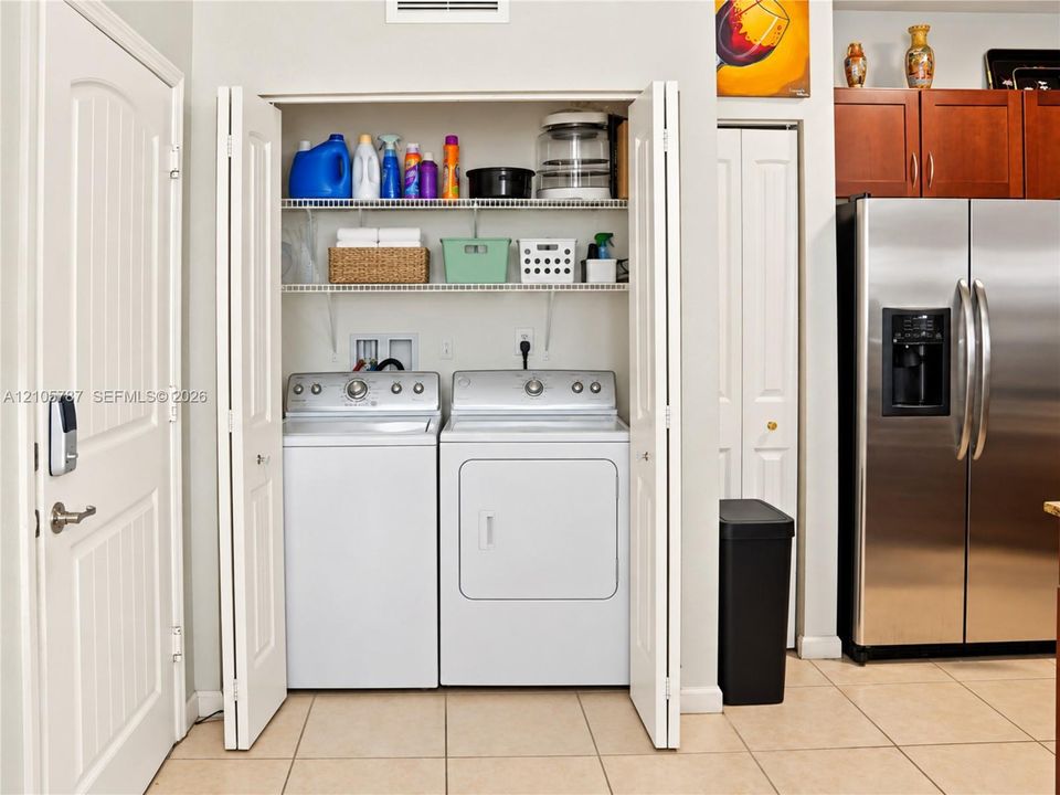 Laundry closet featuring bi-fold doors and tiered wire shelving