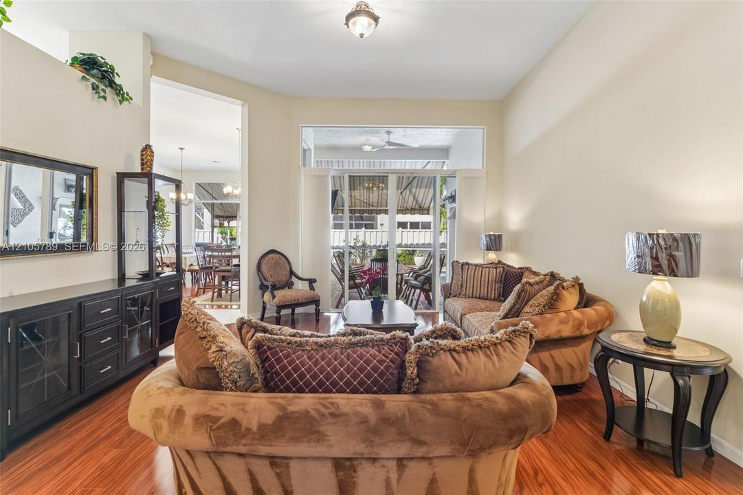 Vaulted ceilings, wood-finish flooring, recessed lighting, and large sliding glass doors with transom windows