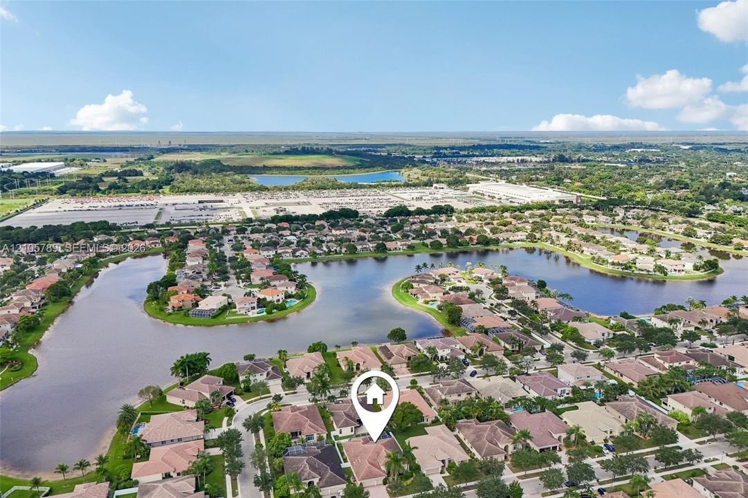 Aerial perspective featuring a multi-pitched roofline, residential lot, and surrounding water frontage