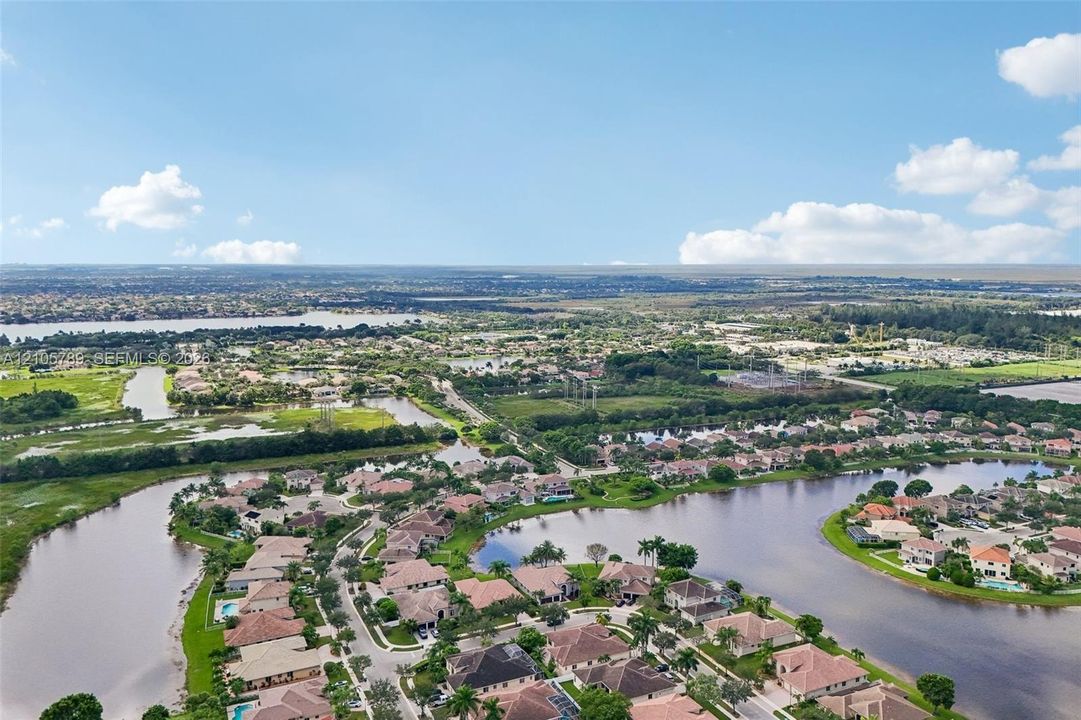Aerial perspective featuring expansive waterway frontage, mature landscaping, and multi-family residential parcels