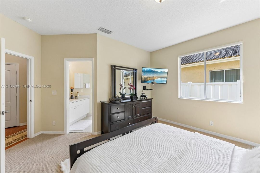 Neutral wall finishes, plush carpeting, multi-panel interior doors, and a large window featuring natural light