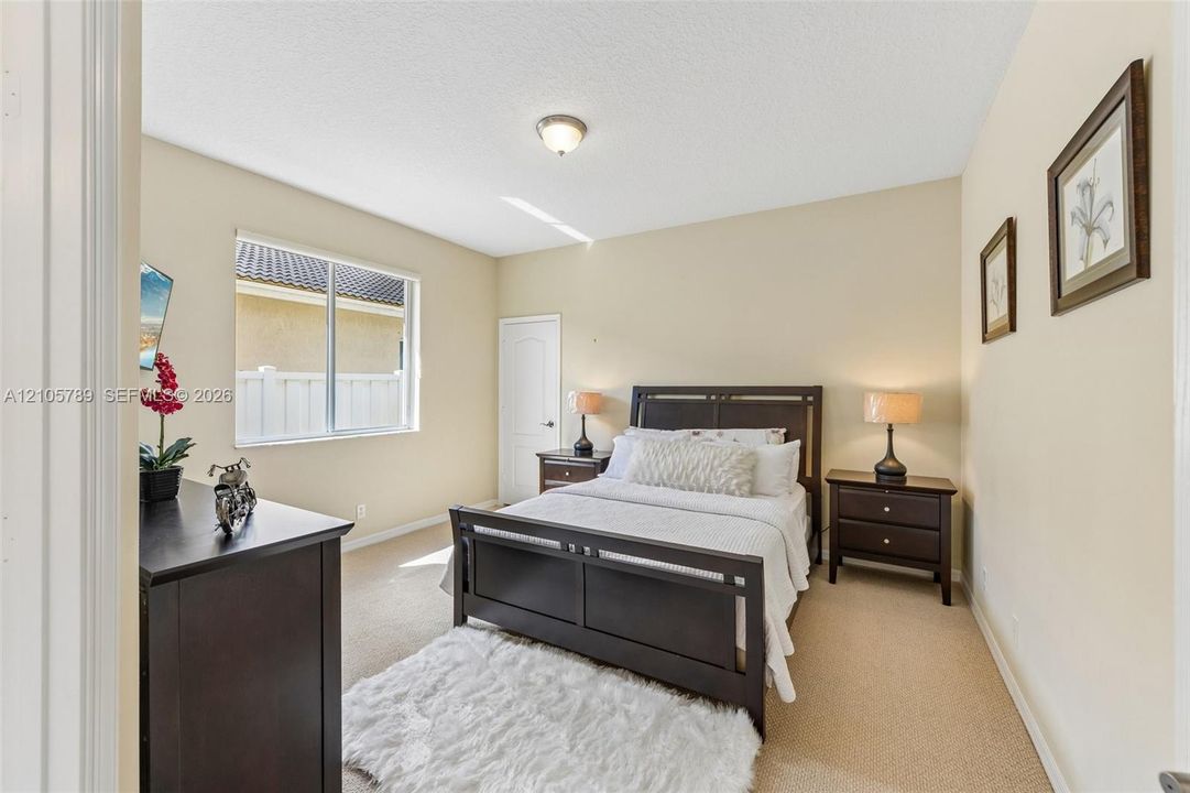 Neutral-toned room featuring wall-to-wall carpeting, a multi-pane sliding window, and a single-panel interior door