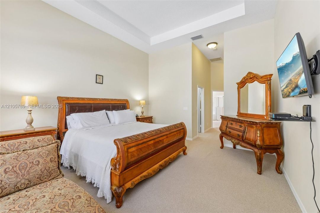 Room featuring high ceilings with crown molding, recessed lighting, and neutral carpeted flooring