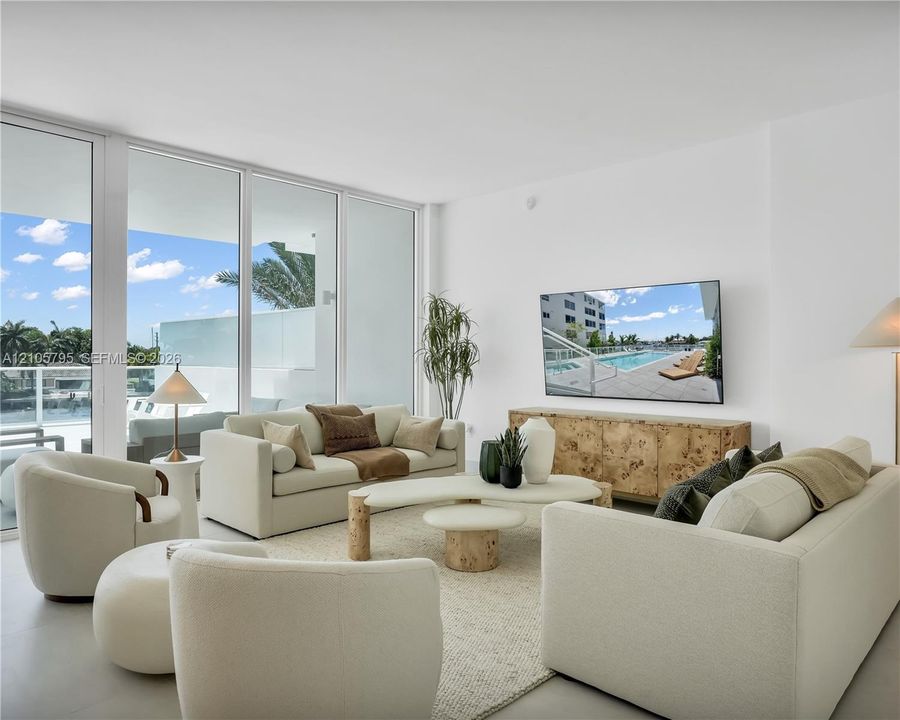 Floor-to-ceiling glass sliding doors, neutral large-format flooring, and direct access to a balcony