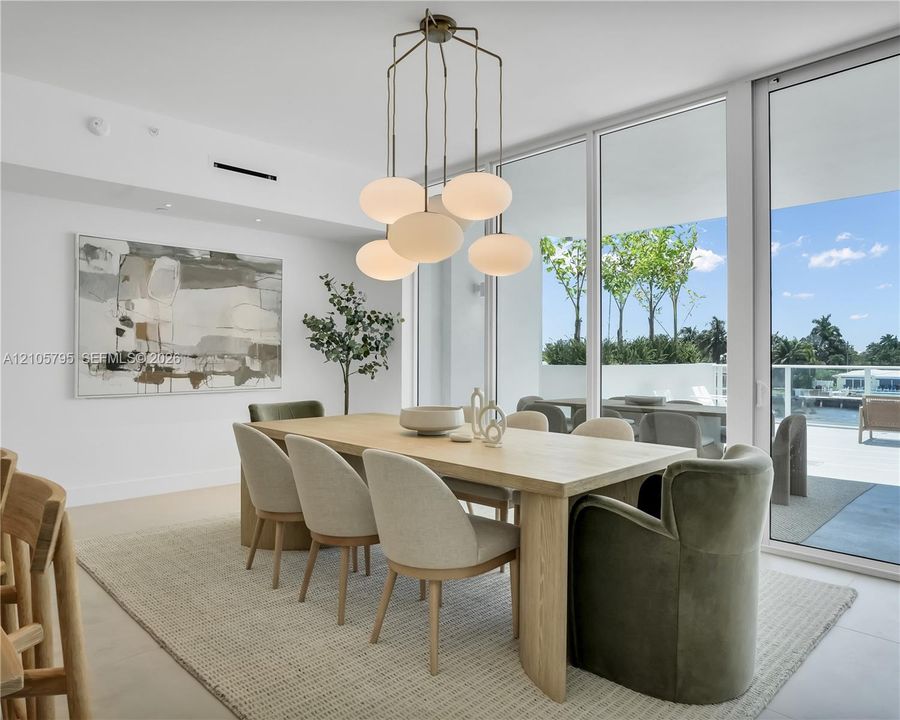 Floor-to-ceiling glass walls, multi-pendant opal glass lighting fixture, and light-toned flooring