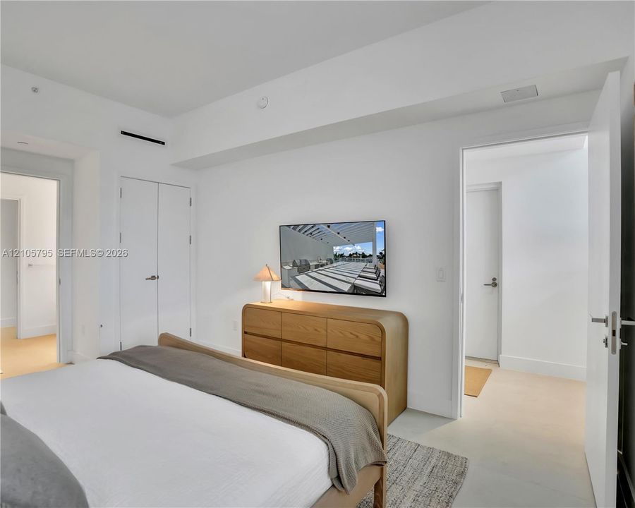 Neutral interior featuring high ceilings, smooth white walls, recessed lighting, and solid-core doors