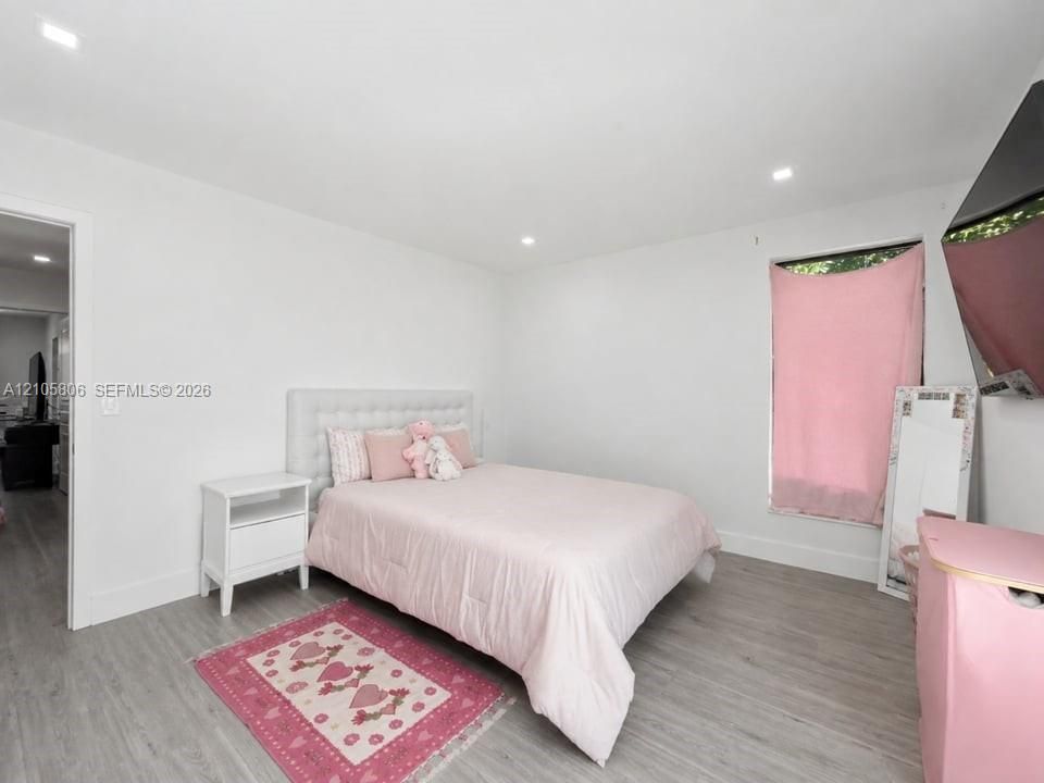 Neutral walls, wood-finish flooring, and recessed lighting