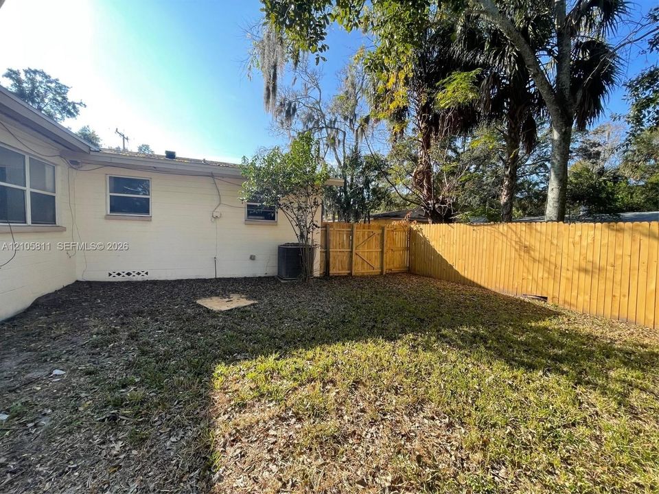 Exterior space featuring a masonry wall, wood privacy fencing, and mature trees