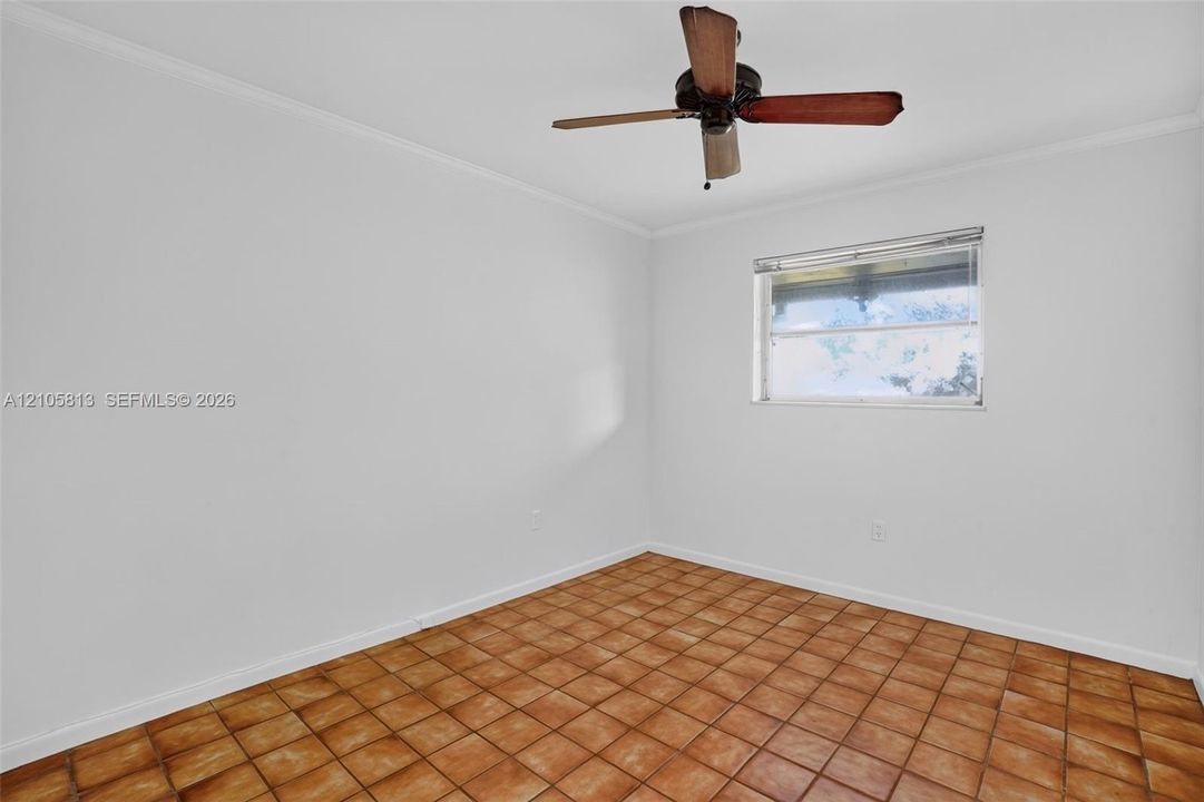 Square tile flooring, neutral wall finishes, single-hung window, and ceiling fan with wood-finish blades