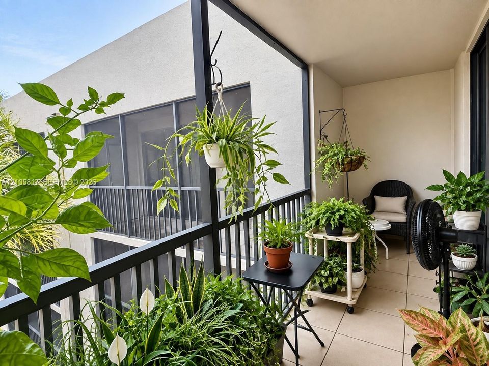 Screened-in balcony featuring tile flooring and a black metal railing