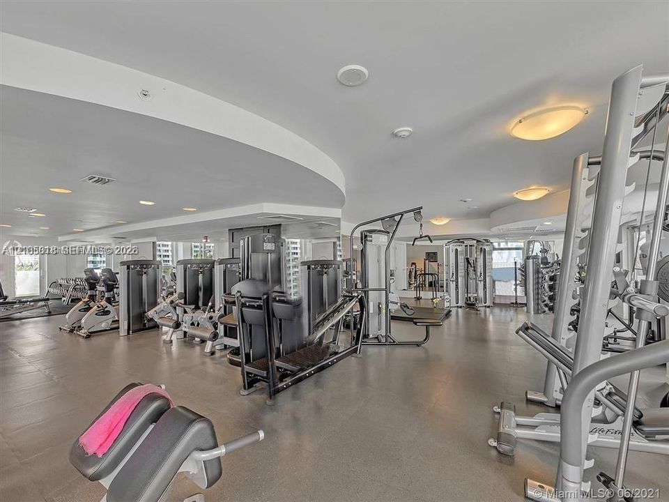 Fitness center featuring recessed lighting, mirrored walls, and specialized rubberized flooring