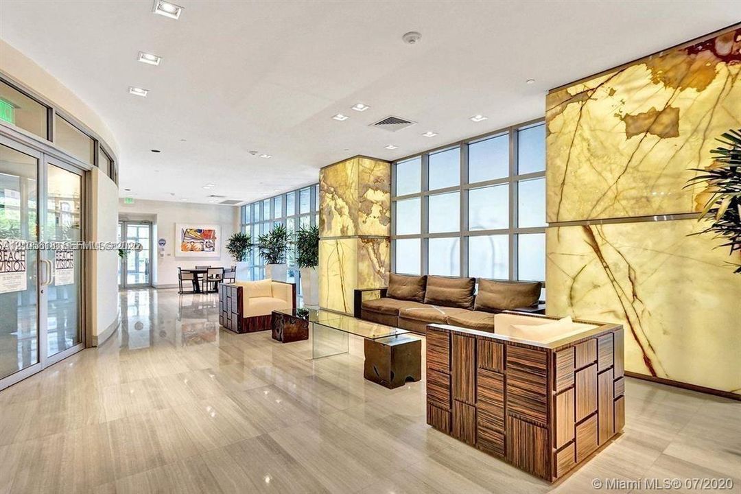 Polished stone flooring, floor-to-ceiling windows, and decorative back-lit stone accent walls