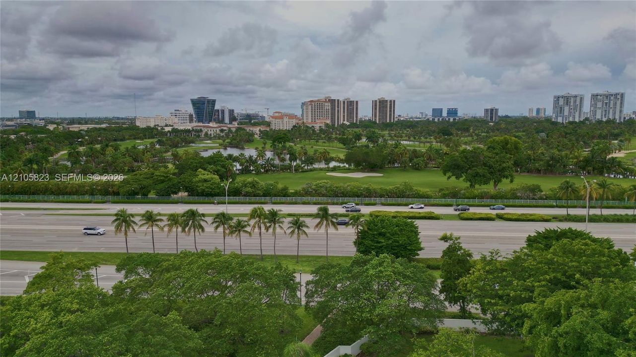 Aerial perspective featuring expansive green space, mature canopy trees, and an open golf course landscape