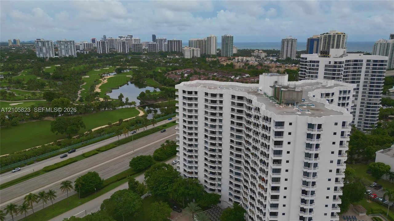 High-rise building with white exterior facade and multiple stacked balconies