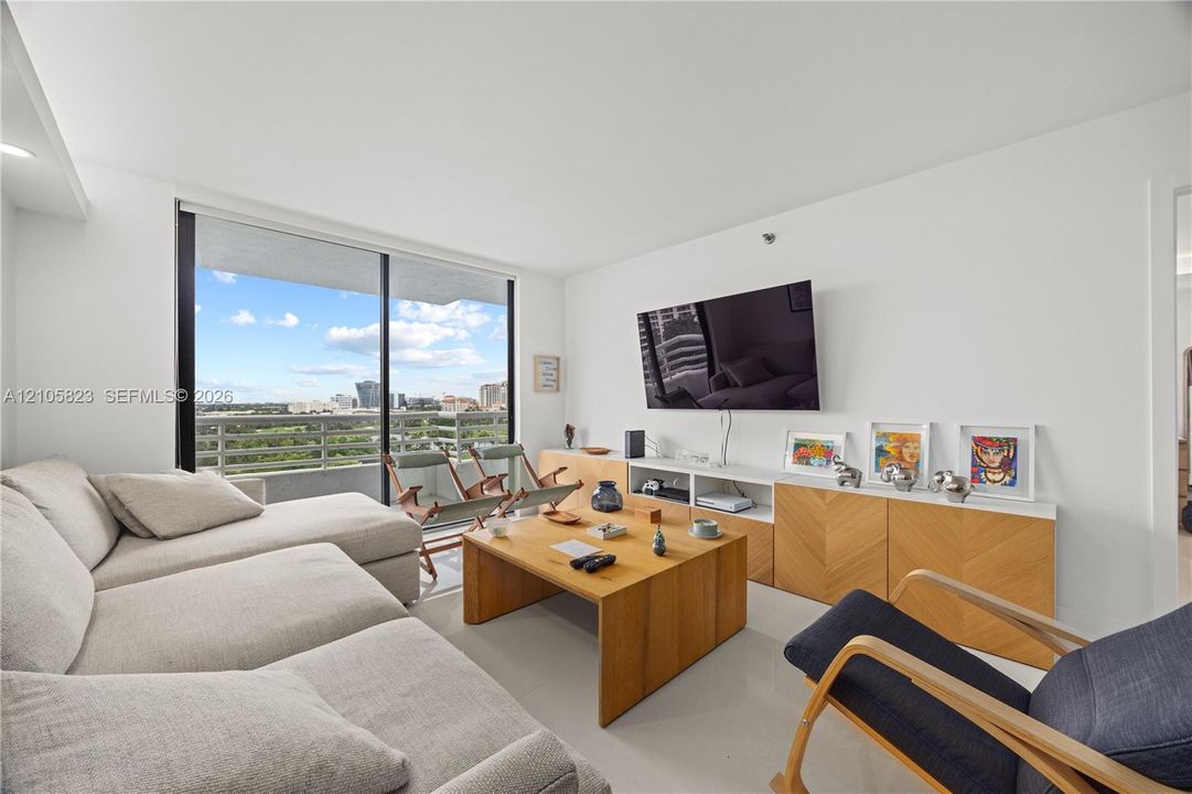 Floor-to-ceiling sliding glass door, balcony with metal railing, smooth-finish ceiling, and light-toned flooring