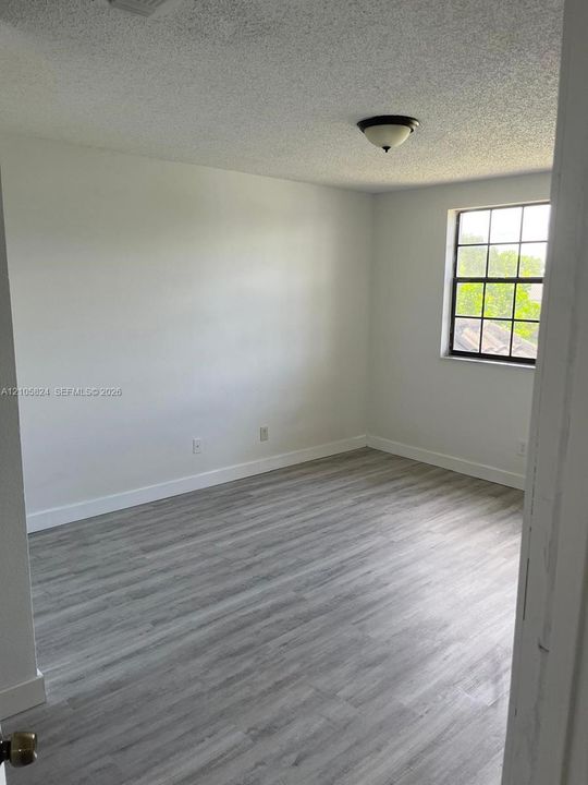 Interior space featuring wood-finish flooring, a multi-pane window, and a dome-style flush mount ceiling light