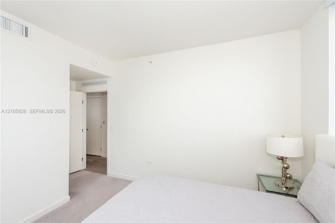 Neutral-toned interior featuring wall-to-wall carpeting, crisp white walls, and solid-core interior doors