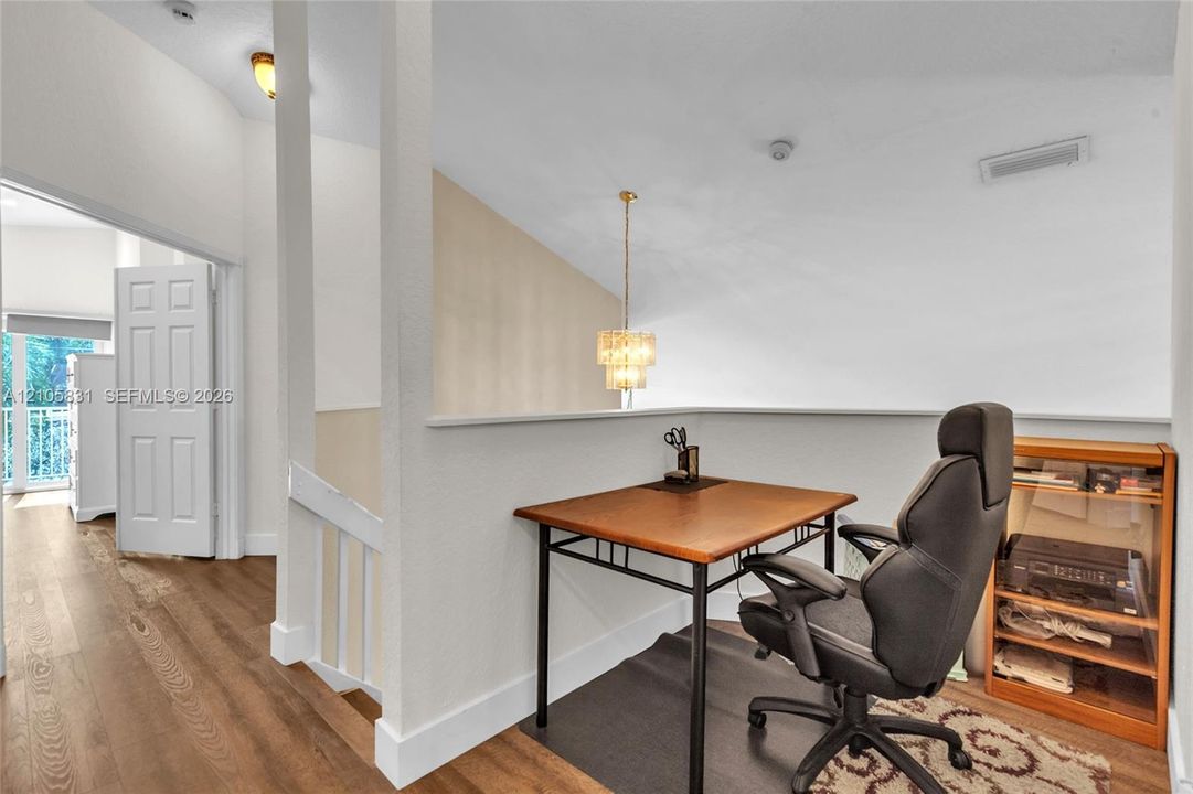 Vaulted ceilings, multi-level pendant lighting, wood-finish flooring, and white interior doors