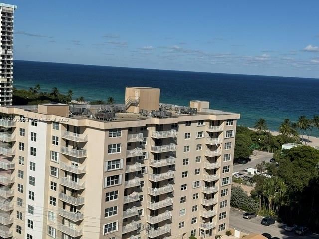 High-rise building featuring private balconies, stucco exterior, and oceanfront positioning