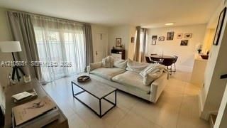 Neutral-toned interior featuring large-format tile flooring and floor-to-ceiling glass sliding doors