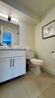 Bathroom featuring a white vanity cabinet with a solid surface countertop, rectangular under-mount sink, polished chrome faucet, and integrated linear vanity lighting