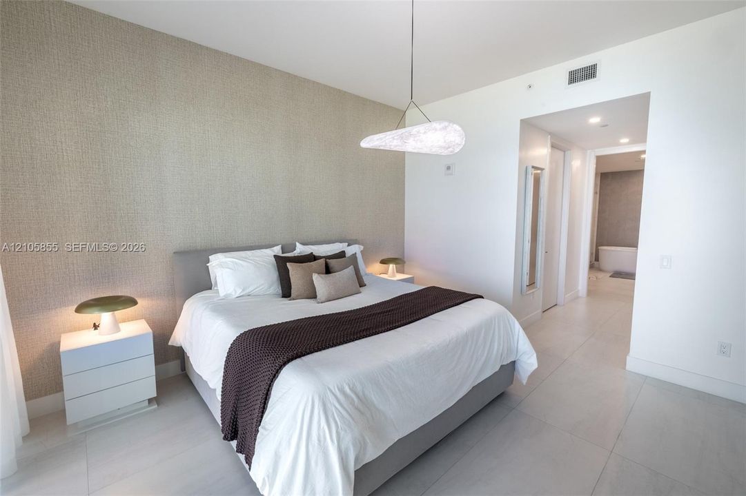 Neutral-toned textured accent wall, polished tile flooring, and custom modern pendant lighting fixture