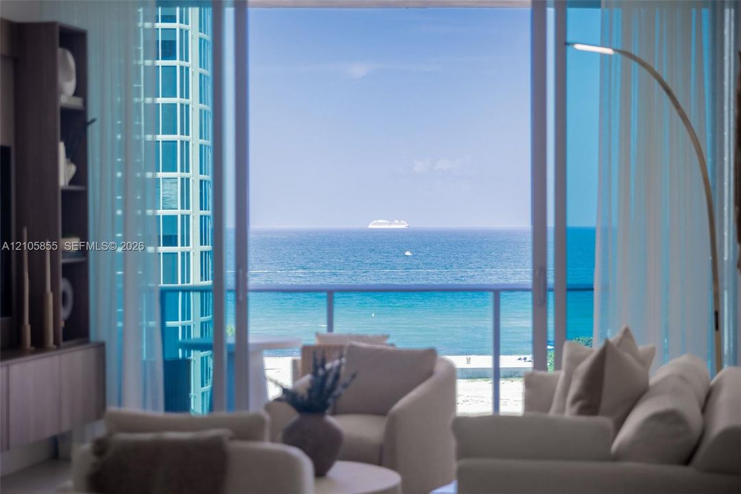 Floor-to-ceiling sliding glass doors opening to a balcony with metal railing, featuring panoramic ocean and coastal scenery