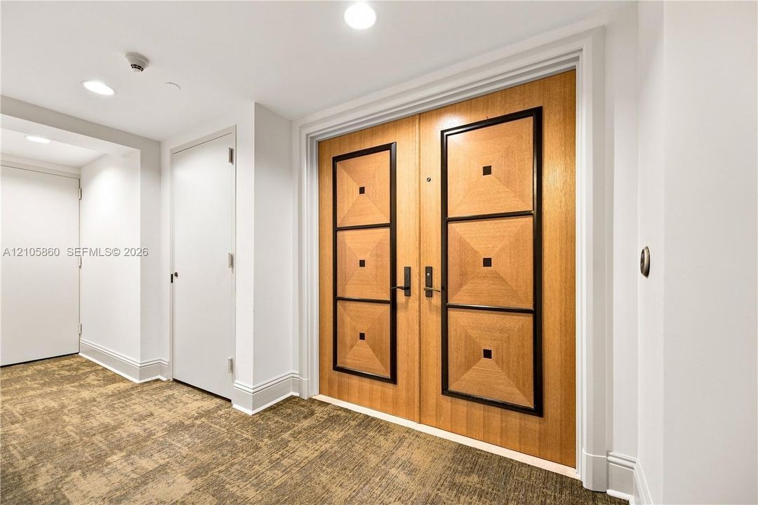 Double-door entry featuring a wood finish with geometric trim detailing and recessed lighting