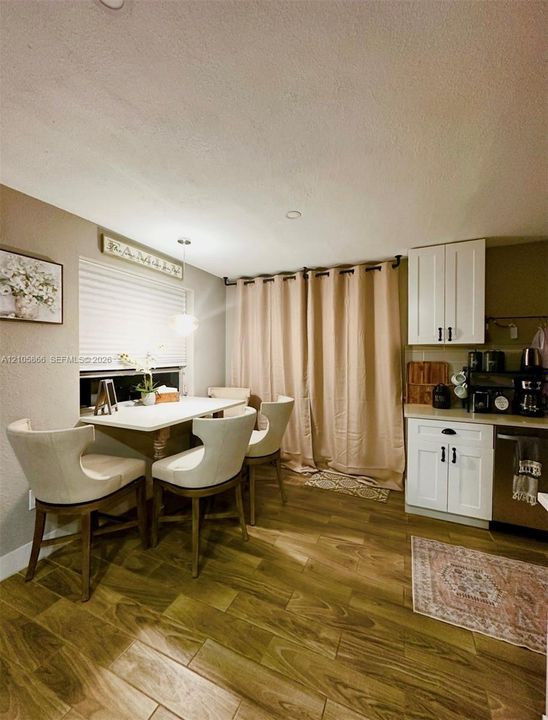 White cabinetry with matte black hardware,Main House wood-finish flooring, and recessed ceiling lighting