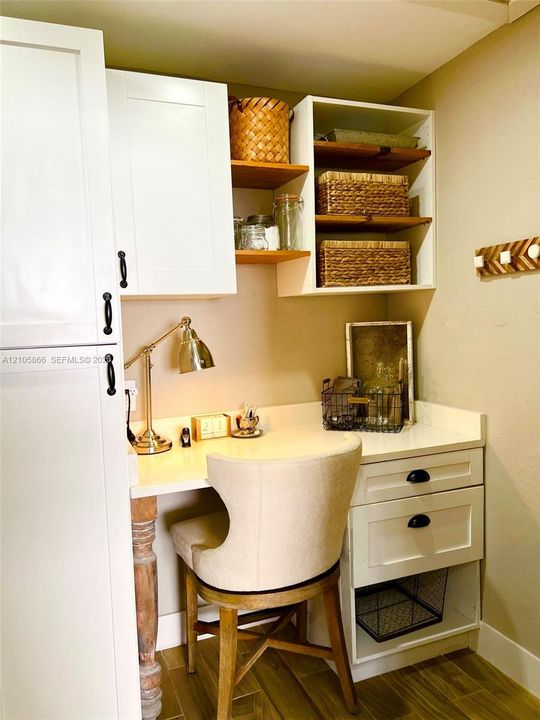 Office/Pantry Built-in workspace featuring white shaker-style cabinetry, solid surface countertop, open shelving, and wood-finish flooring