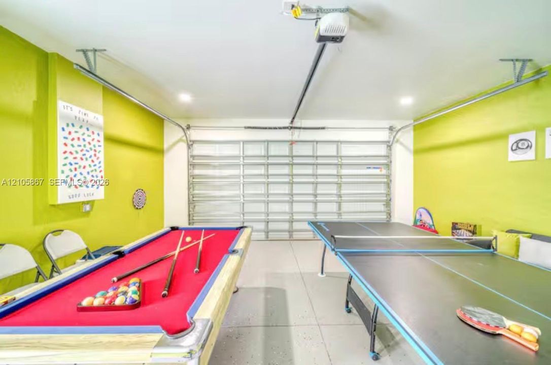 Attached two-car garage featuring a sectional metal door, epoxy-coated flooring, and recessed ceiling lighting