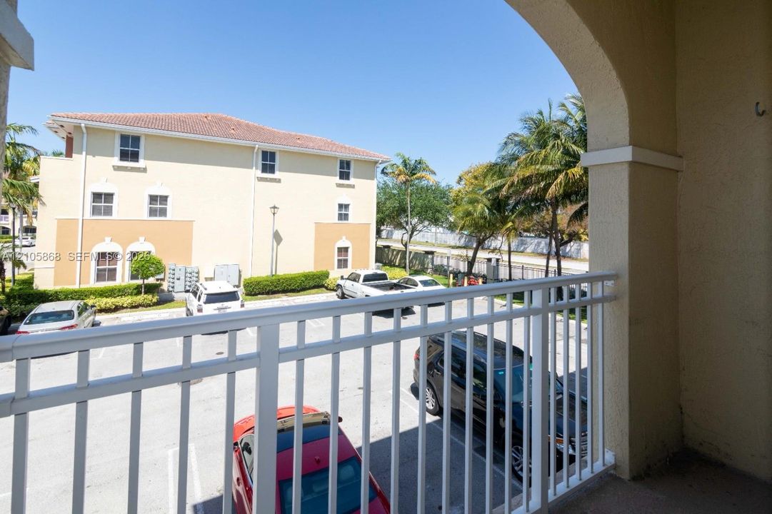 Covered balcony featuring an arched architectural opening and white metal railing