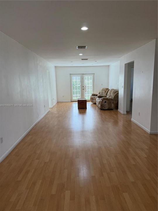 Wood-finish flooring, recessed lighting, and double glass-paned doors