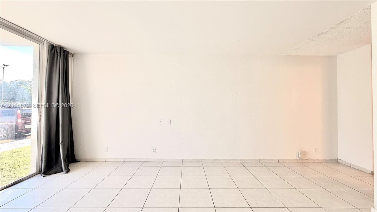 Interior space featuring large-format ceramic floor tile and floor-to-ceiling glass sliding doors