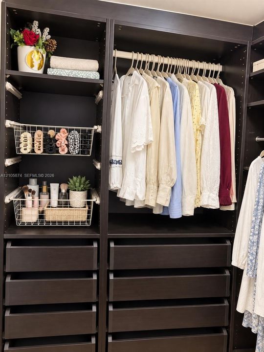 Custom dark wood-finish cabinetry featuring integrated shelving, pull-out wire storage baskets, and multiple deep-drawer compartments