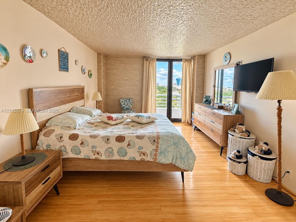 Wood-finish flooring, textured ceiling, and floor-to-ceiling glass patio door