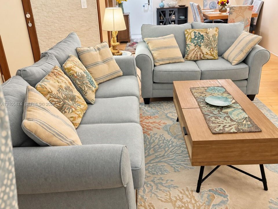 Open-concept interior featuring wood-finish flooring and textured stone accent wall