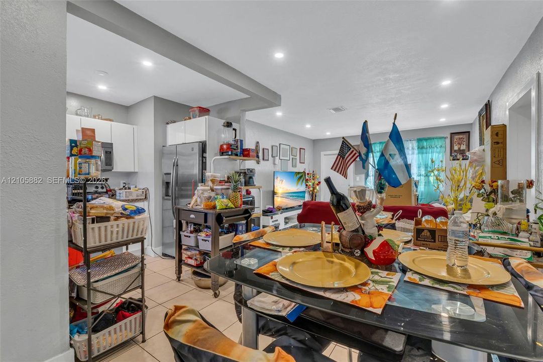 Open-concept interior featuring recessed lighting, ceramic tile flooring, and white flat-panel cabinetry