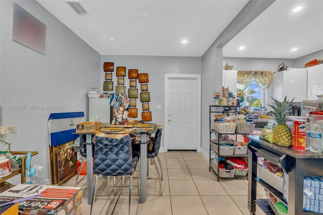 Ceramic tile flooring, recessed lighting, and white interior door