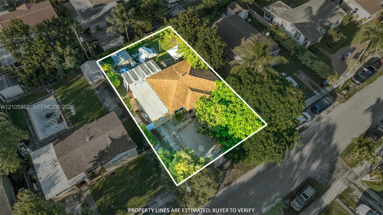 Aerial perspective of a property featuring a hip roof, multi-level structure, paved driveway, and mature landscaping