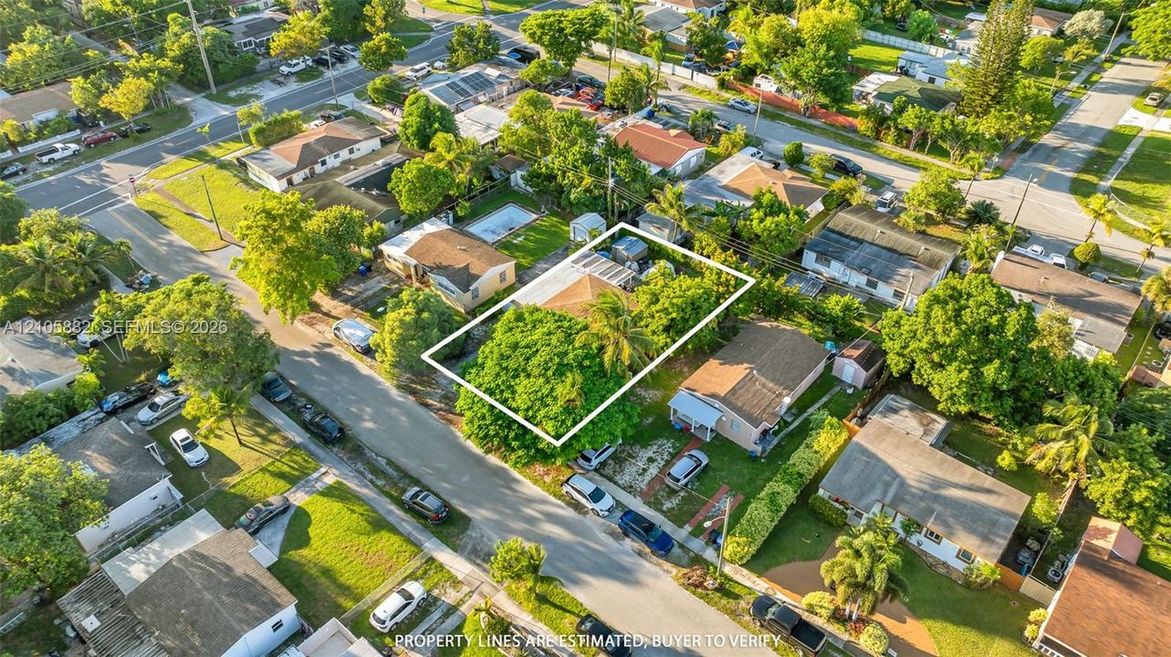 Aerial perspective featuring a shingled roof, mature tree canopy, and established residential lot layout