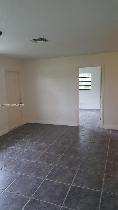 Interior space featuring neutral wall paint, large-format tile flooring, and a multi-pane window