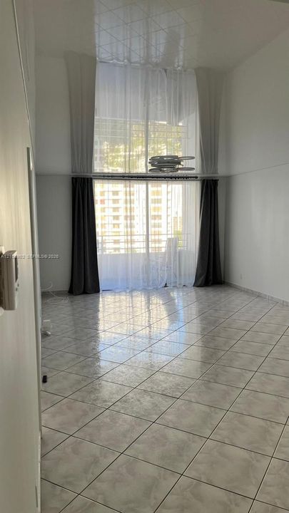 High ceilings, light-reflective tile flooring, and floor-to-ceiling glass paneling