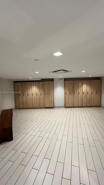 Room featuring extensive wood-finish cabinetry, recessed ceiling lighting, and light-toned ceramic tile flooring