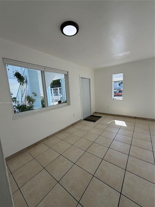 Neutral-toned tile flooring, large-format windows, and a flush-mount overhead light fixture