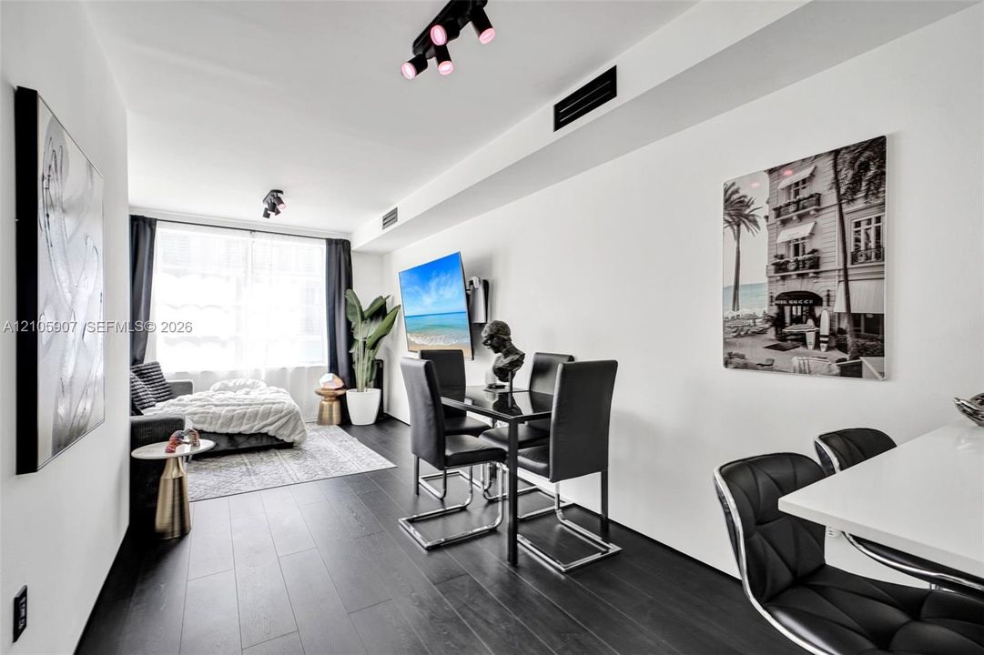 Dark wood-finish flooring, adjustable track lighting, and crisp white wall finishes