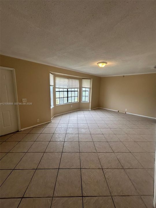 Interior space featuring ceramic tile flooring, a multi-pane bay window, and a flush-mount ceiling light fixture