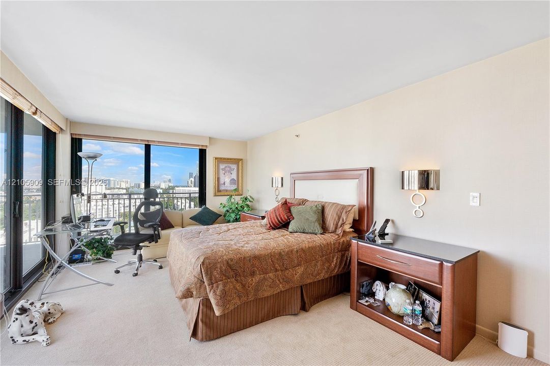 Floor-to-ceiling windows, wall-mounted light fixtures, and wall-to-wall carpeting