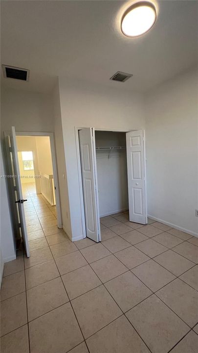 Room featuring ceramic tile flooring, a closet with double-panel doors, and a ceiling-mounted light fixture