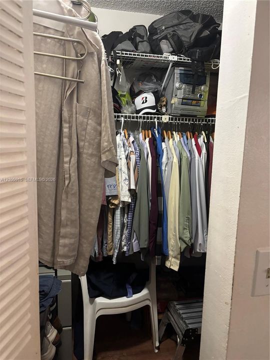 Closet featuring tiered wire shelving and louvered folding doors